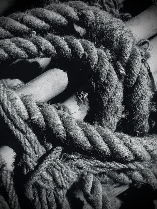 Thick rope is tightly wound around wooden objects.