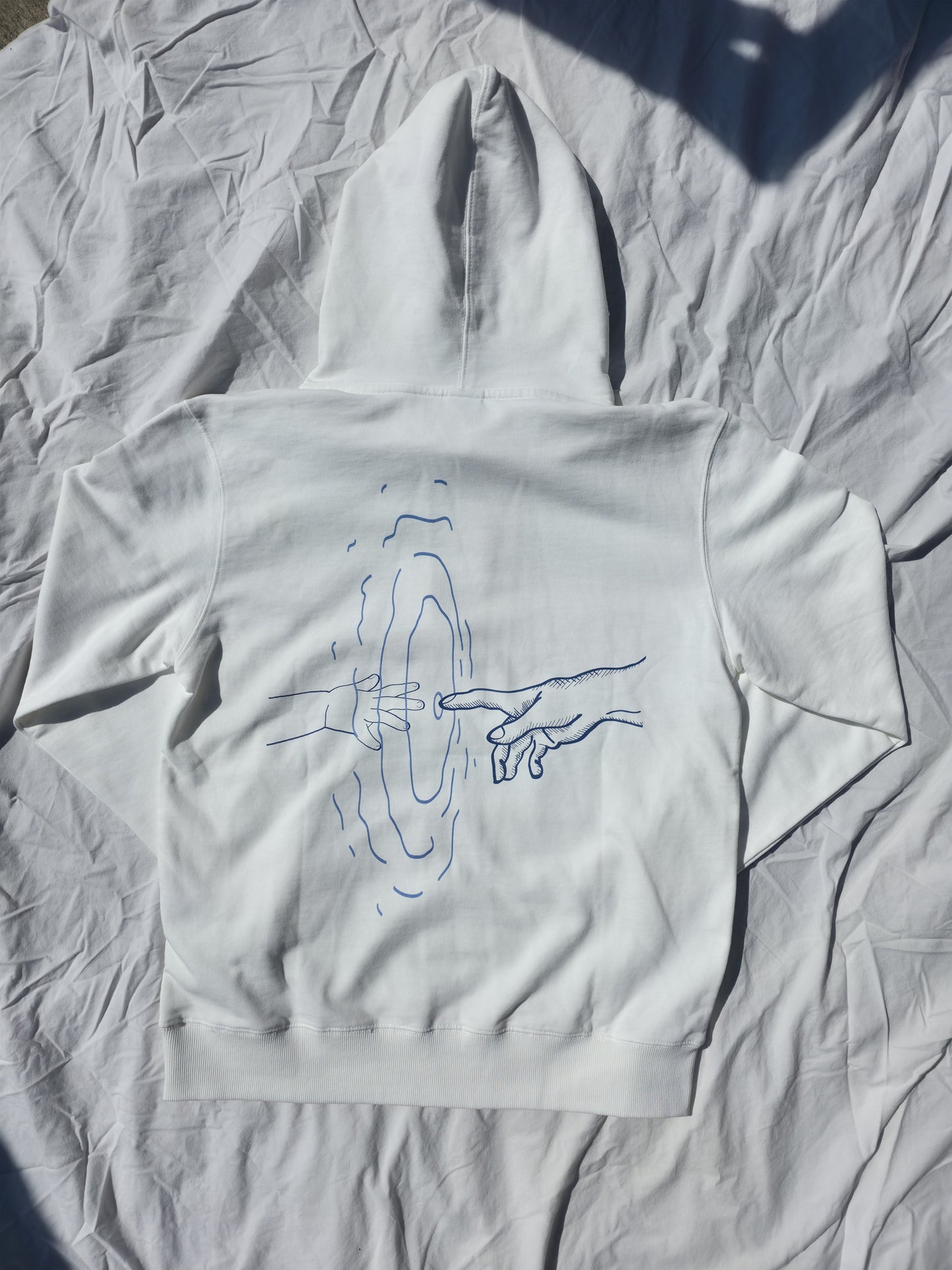 White 100% cotton hoodie featuring minimalist hand and ripple linework design symbolizing legacy from Infinite Co’s ECHOES collection, crafted from sustainable natural fibers for modern streetwear.