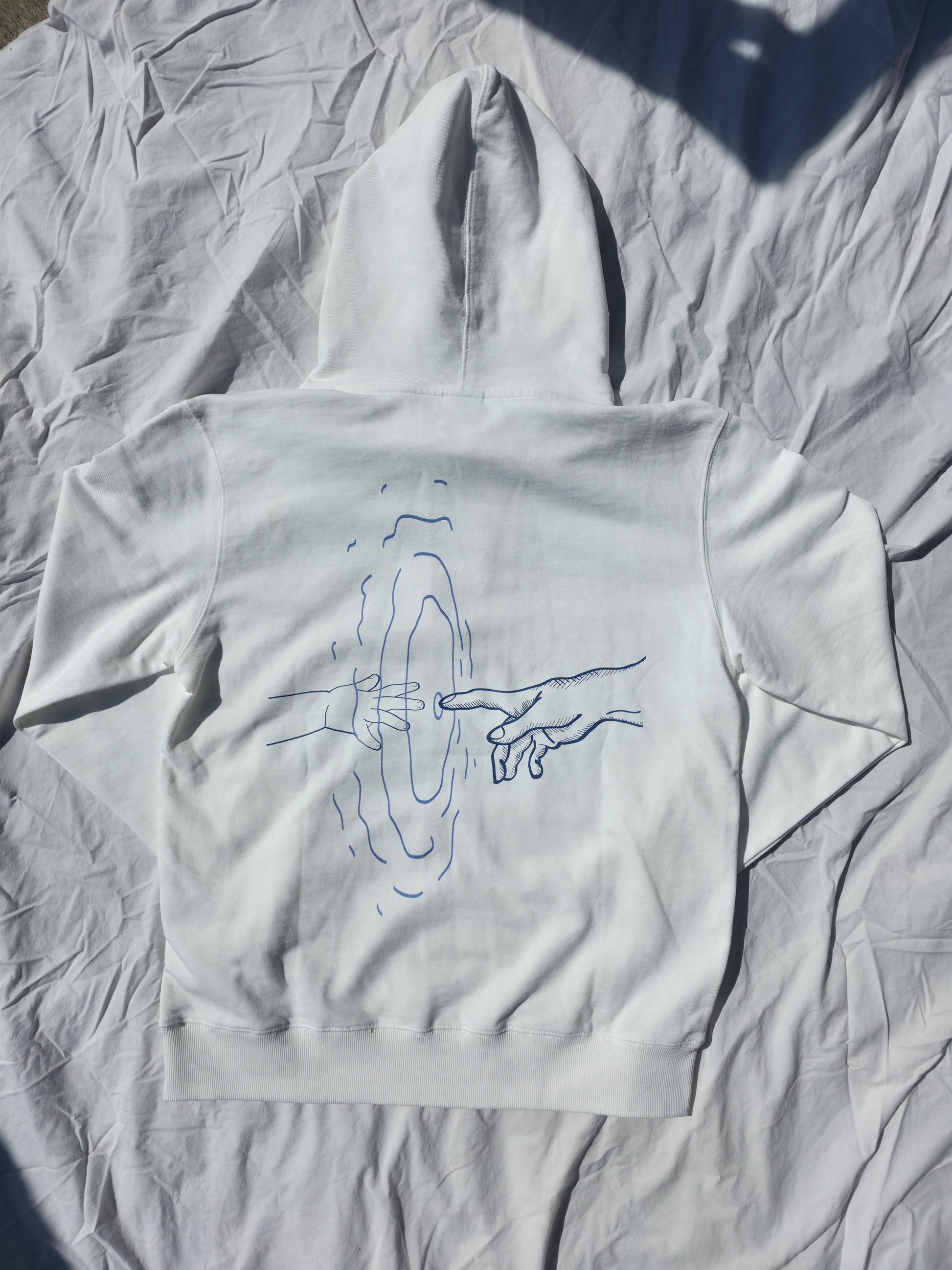 White 100% cotton hoodie featuring minimalist hand and ripple linework design symbolizing legacy from Infinite Co’s ECHOES collection, crafted from sustainable natural fibers for modern streetwear.