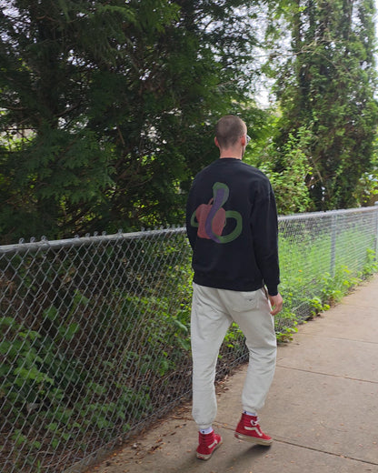 Person wearing EDEN Oversized Crewneck and ECHOES Cloud Comfort Pants walking on a path with trees and a fence in the background